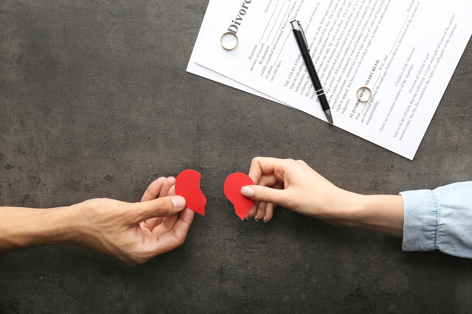 Hands of Couple with Broken Heart on Dark Background